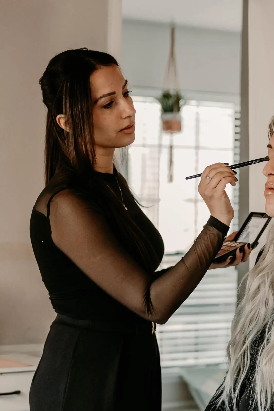Sivan, founder and lead makeup artist, applying makeup at her Plano studio